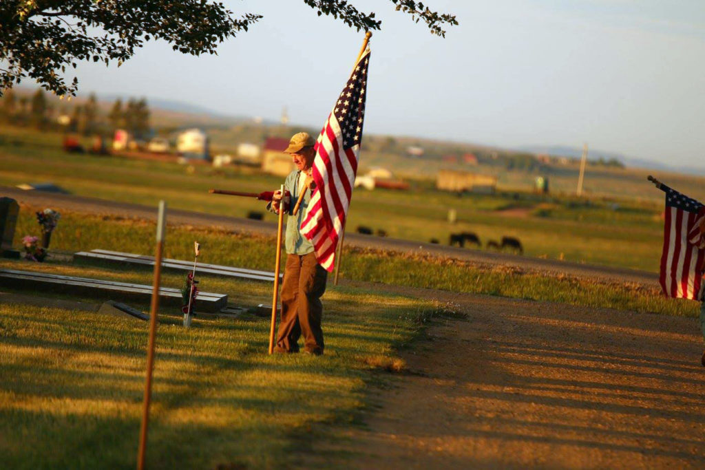 Dan Peterson, a veteran of the North Dakota National Guard, flies flags inside the Bowman Cemetery. Its a Memorial Day tradition each year. (Photo by Chris Peterson)