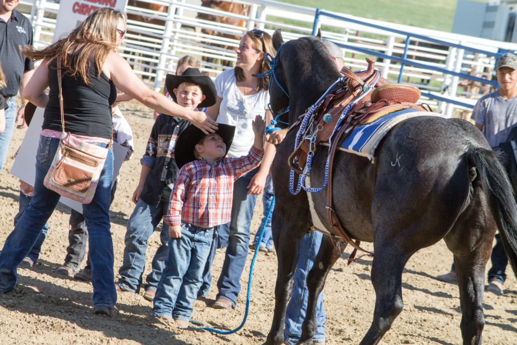 Luke Kilzer reaches up to pet his new horse June 17 in Bowman. He received the horse as a surprise from Make-A-Wish, though the group is actively searching for a different horse since the Black Daddy was “too spirited.” (Pioneer Photo by Bryce Martin)
